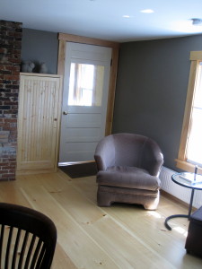 Our house has a spacious library in the ell, next to the kitchen (K. is through the door in center of photo.)  This photo shows a reading chair, next to 3 south-facing windows, which look out onto the front yard.  To the left (not shown) is the back door to the house, leading onto a small porch. Behind me, not shown, are the bookshelves, which have lots of books, some good magazines, a screen for watching movies, drawers of games (chess, board games, cards), some jigsaws, some wood blocks, crayons and paper.  There's also a large work table to the left (edge of chair is visible), and we have fairly reliable wifi.